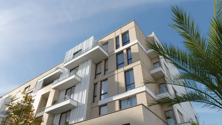 A Picture for CIV West Modern multi-story residential building with large windows and balconies with glass railings. The facade features a mix of stone-like textures and smooth, light-colored surfaces. Greenery is visible on the balconies and in the foreground, with palm trees and other plants adding to the aesthetic appeal under a clear sky with wispy clouds
